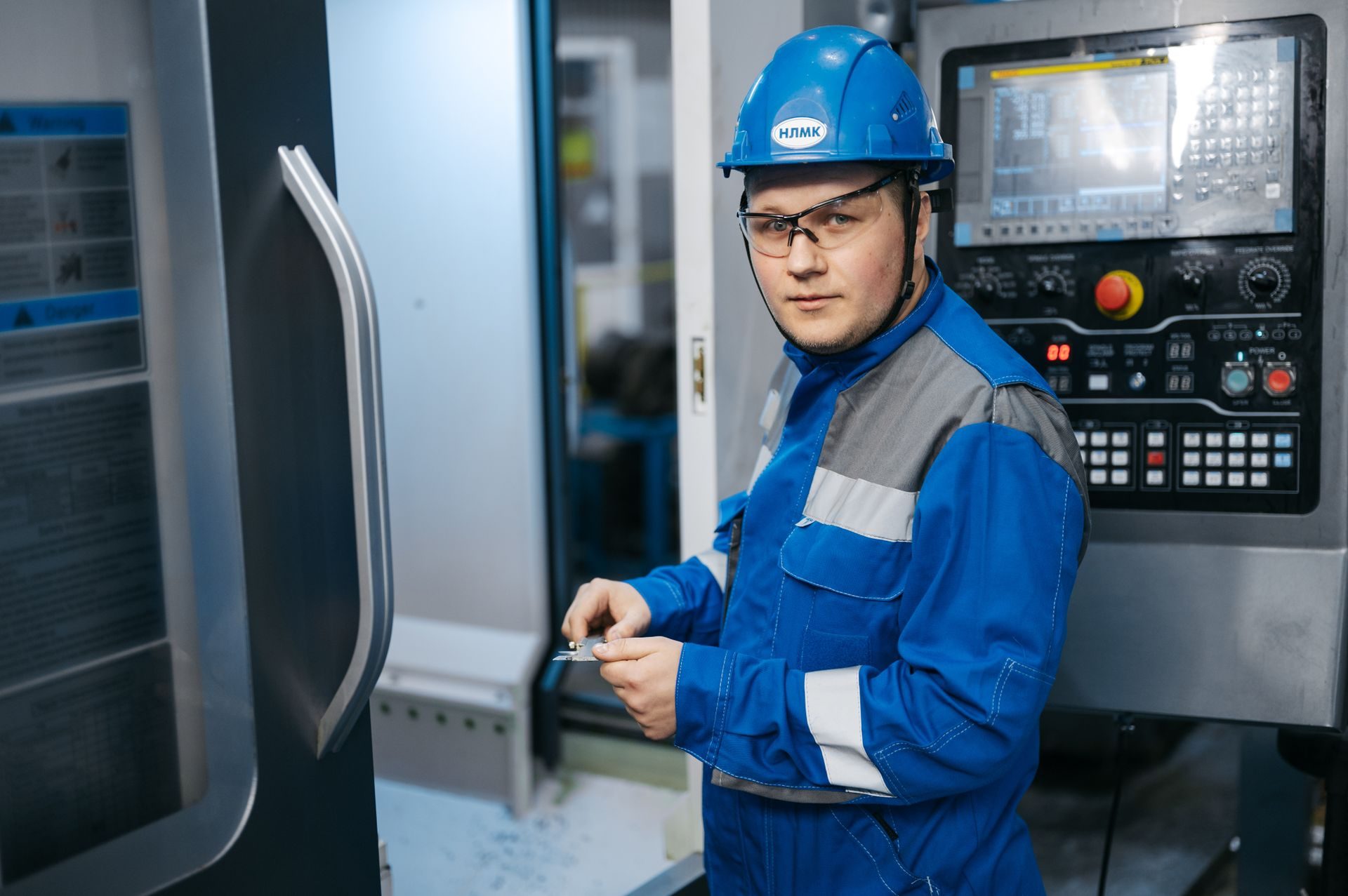Industrial engineer operating a CNC machine in a modern factory